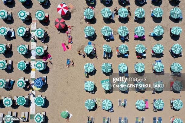 An aerial photograph taken on August 22 shows parasols on a beach of the Adriatic Sea in Durres, as a heatwave sweeps through Europe. Due to the...