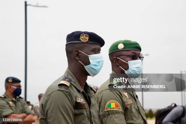 The spokesperson for the CNSP Ismael Wague and Vice president of the CNSP Malick Diaw, wearing face masks, wait to greet former Nigerian president as...