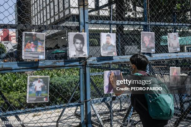 An activist hangs a picture of a missing man after lifting an "anti-monument" to mark the 10th anniversary of the San Fernando Massacre in which 72...