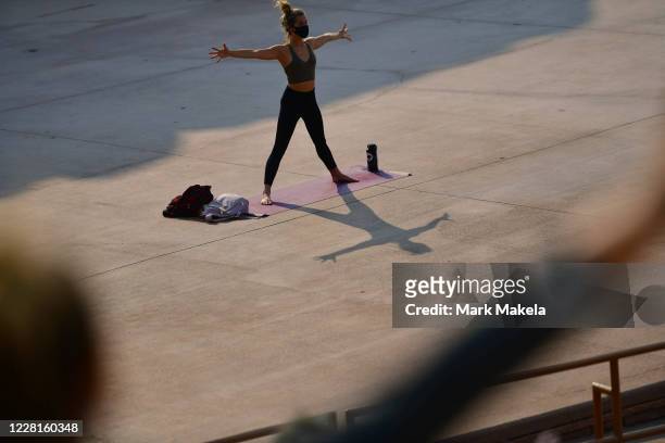 Yoga instructor guides participants in a morning yoga session on August 22, 2020 at the Red Rocks Amphiteatre in Morrison, Colorado. The famed...