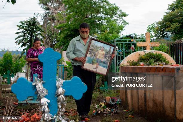 Salvadoran Mirna del Carmen Solorzano and her husband Miguel Angel Medrano visit the grave of their daughter Glenda, at the municipal cemetery in...