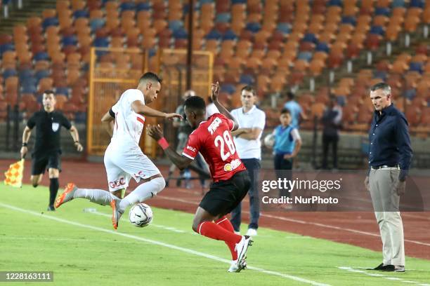 Ahly's player Junior Ajayi in action with Zamalek player Hazem Emam during the first derby between Zamalek and Al-Ahly after the return of the...