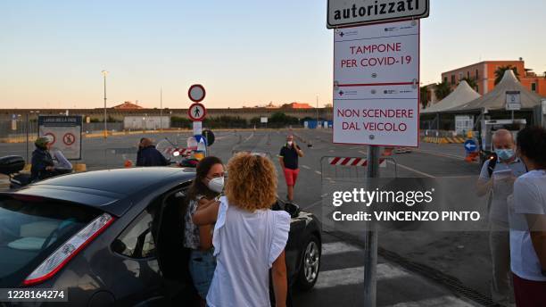 Holidaymakers returning from Sardinia by ferry wait to undergo a compulsory drive-through swab test on August 23, 2020 at the port of Civitavecchia,...