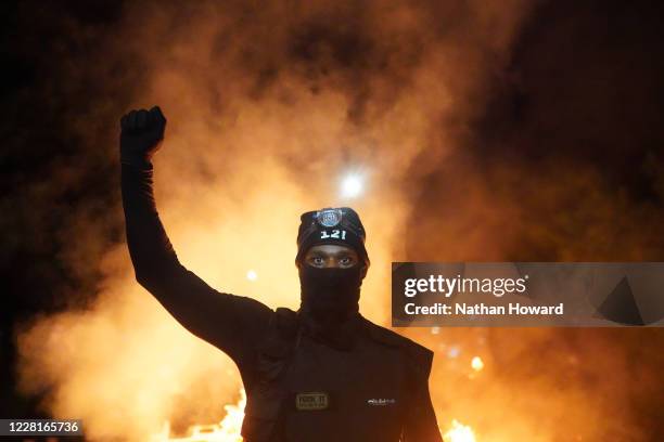 Protester holds his fist in the air during a protest against racial injustice and police brutality early in the morning on August 23, 2020 in...