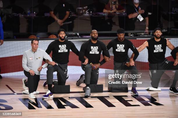 Frank Vogel, Anthony Davis, LeBron James, Kentavious Caldwell-Pope and JaVale McGee of the Los Angeles Lakers kneels during the National Anthem...