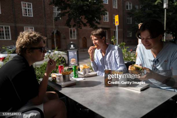Tim Dahlsedt, aged 16, Gösta Jansson, aged 15, and Bernard Jegebäck Nisell, aged 15, who are all friends from the Scout Corps, eat burgers at a...