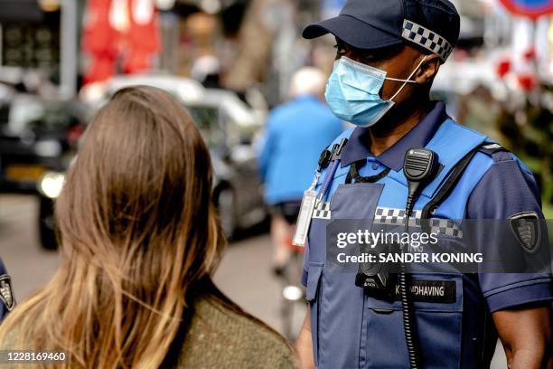 Dutch police officer wears a nose and face mask as the municipality of Rotterdam enforces the mandatory wearing of mask in large parts of the city to...