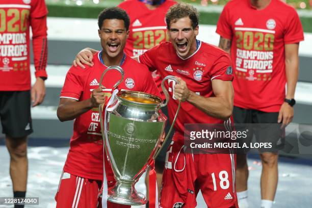 Bayern Munich's German midfielder Serge Gnabry and Bayern Munich's German midfielder Leon Goretzka celebrate with the trophy after the UEFA Champions...