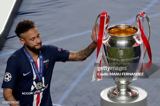 Paris Saint-Germain's Brazilian forward Neymar touches the trophy after the UEFA Champions League final football match between Paris Saint-Germain...