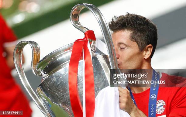 Bayern Munich's Polish forward Robert Lewandowski holds the Polish flag and kisses the trophy after Bayern won the UEFA Champions League final...
