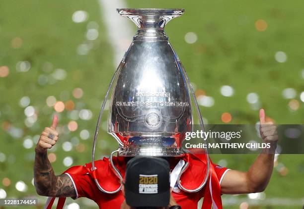 Bayern Munich's French defender Lucas Hernandez poses with the trophy upside down on his head after Bayern won the UEFA Champions League final...