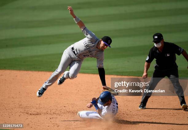 Trevor Story of the Colorado Rockies tags out Cody Bellinger of the Los Angeles Dodgers at second base during a steal attempt on a throw after a...