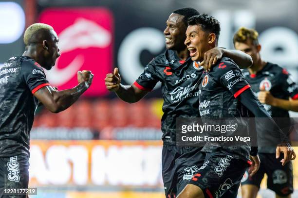 Bryan Angulo of Tijuana celebrates with teammates Fabian Castillo and Ivan Lopez after scoring the first goal of his team during the 6th round match...