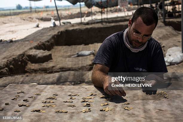 Israeli archaeologist Shahar Krispin counts gold coins dating to the Abbasid Caliphate during a press presentation of the discovery at an...