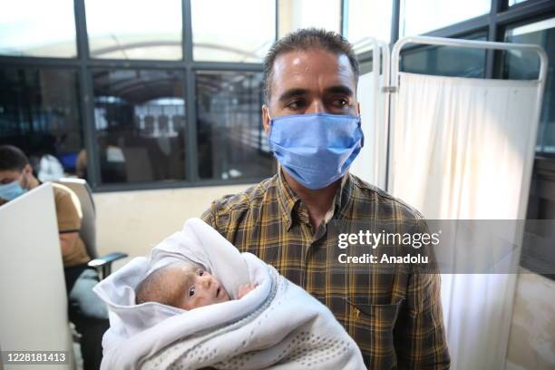 Day-old Syrian baby Mutaz with fish scale disease is hold by his father Muhanned Kahil in Hatay, Turkey on August 24, 2020. Baby Mutaz were brought...