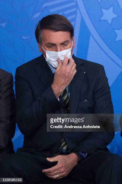 Jair Bolsonaro President of Brazil touches his protective mask during the "Brazil Vencendo a COVID" event amidst the coronavirus pandemic at the...