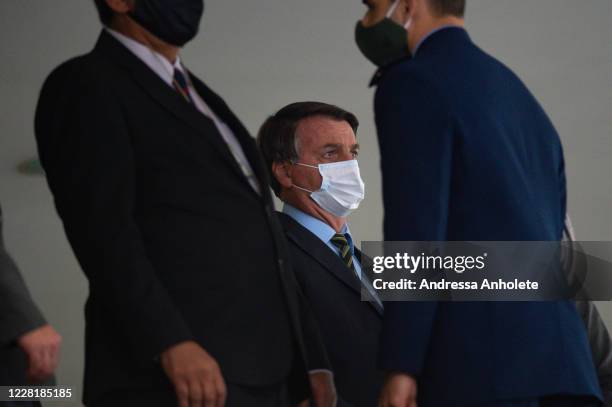 Jair Bolsonaro, President of Brazil, looks on wearing a protective mask before the "Brazil Vencendo a COVID" event amidst the coronavirus pandemic at...