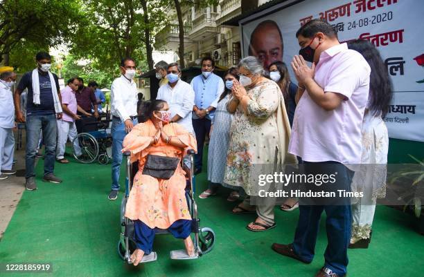 Family members of Arun Jaitely distribute wheel chair to a child with physical disabilities to mark his first death anniversary, at his residence at...