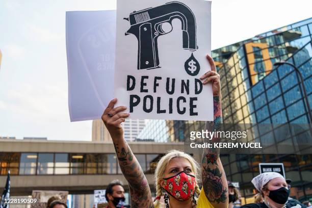 Protester hold a sign reading "Defund the Police" outside Hennepin County Government Plaza during a demonstration against police brutality and...