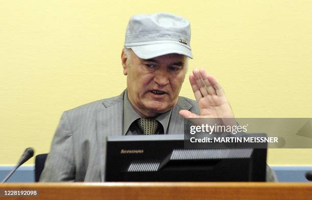 Wartime Bosnian Serb General Ratko Mladic wearing a cap salutes in the court room at his initial appearance at the UN Yugoslav war crimes tribunal in...