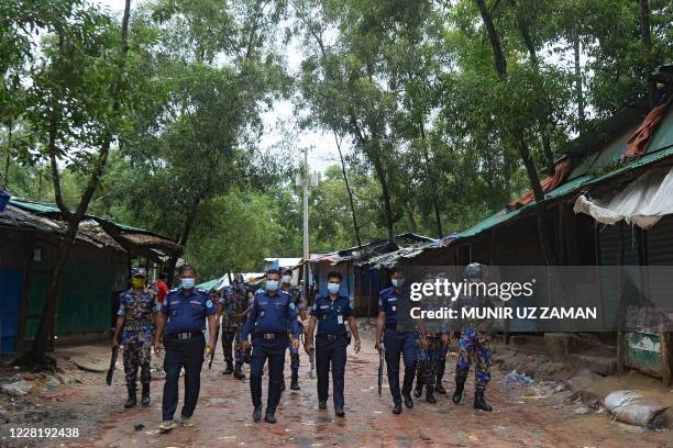 Policemen patrol through a closed market of Rohingya refugees in Kutupalong refugee camp near Ukhia on August 25, 2020. - Almost a million Rohingya...