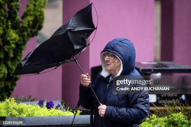 Pedestrian struggles with her umbrella against the wind in Glasgow city centre on August 25 as Storm Francis brings rain and high winds to the UK.