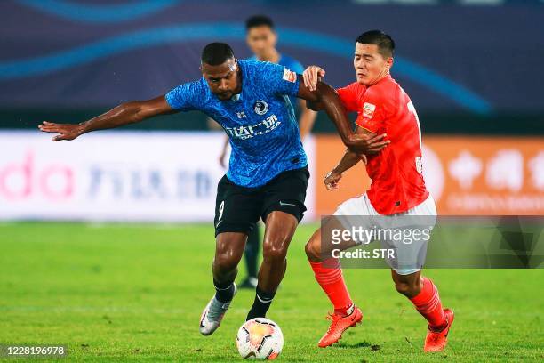 Dalian Pro's Jose Salomon Rondon fights for the ball with Guangzhou Everygrande's Huang Bowen during their Chinese Super League football match in...