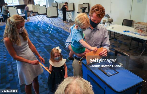 Congressman Joe Kennedy III helps his 3-year-old son James Matthew enter his ballot while at the Newton Free Library in Newton, MA on Aug. 22, 2020....