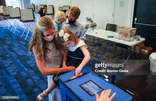 Lauren Anne Birchfield helps her 4-year-old daughter Ellie enter her ballot while her husband Congressman Joe Kennedy III and son, James Matthew,...