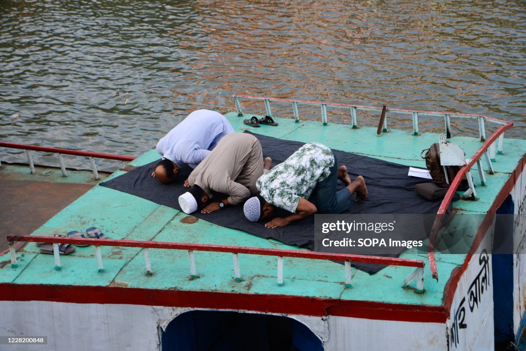 Muslim men are seen praying on a boat in the Buriganga river...