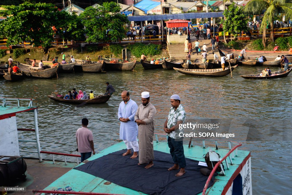 Muslim men are seen praying on a boat in the Buriganga river...