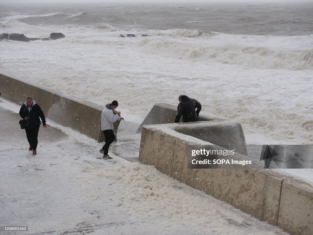 People are seen at the sea wall at Porthcawl South Wales as...