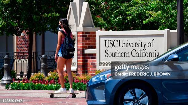 Student skateboards to campus at the University of Southern California in Los Angeles, California on August 25, 2020 where coronavirus cases have...