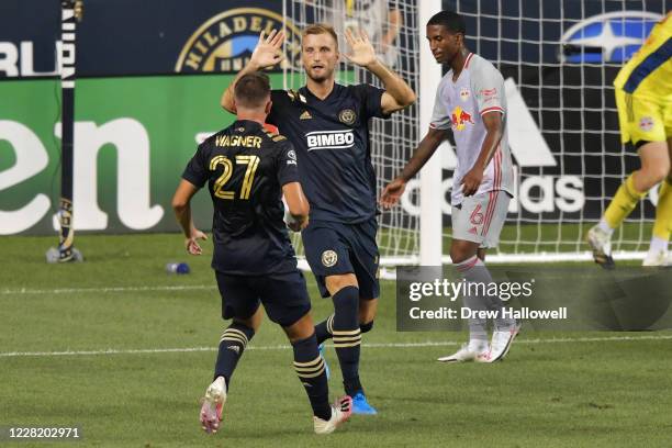 Kacper Przybylko and Kai Wagner of Philadelphia Union celebrate a first half goal in front of Kyle Duncan of New York Red Bulls at Subaru Park on...