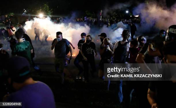 Protestors run for cover as police shoots teargas in an effort to disperse the crowd outside the County Courthouse during demonstrations against the...