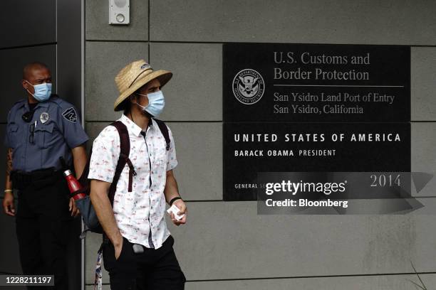 Person wearing a protective mask enters from Mexico at the San Ysidro port of entry in San Diego, California, U.S., on Tuesday, Aug. 25, 2020. The...