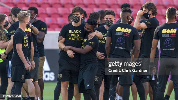 Latif Blessing of the Los Angeles FC is hugged by a team member as they meet with members of Real Salt Lake before their game was postponed at Rio...