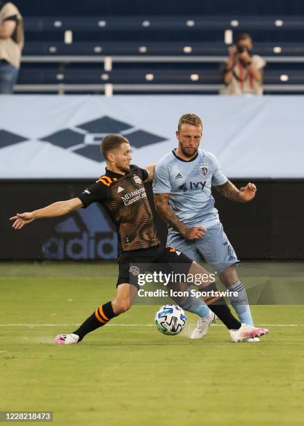 Houston Dynamo defender Adam Lundqvist steps in front of Sporting Kansas City forward Johnny Russell to play the ball in the first half of an MLS...