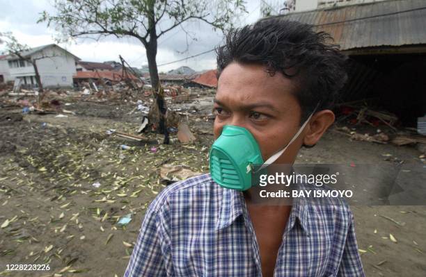 Young Acehnese man tries to locate his family and house near the ruins of the collapsed building in Banda Aceh, 02 January 2004, seven days after the...