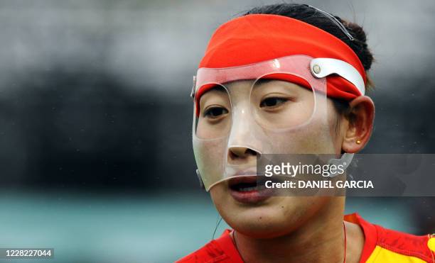 China's Huang Xuejiao wears a mask during the field hockey Group B match against England for the Women World Cup 2010 in Rosario, Argentina, on 31...