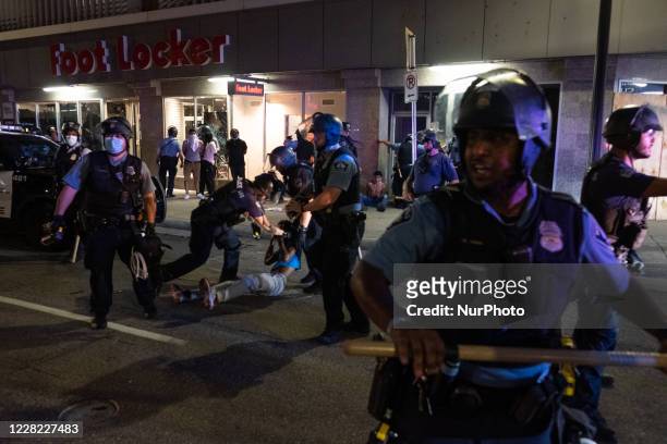 Police pull a man from the crowd after pepper spraying him. He was arrested for refusing to back away from officers downtown Minneapolis, US on...