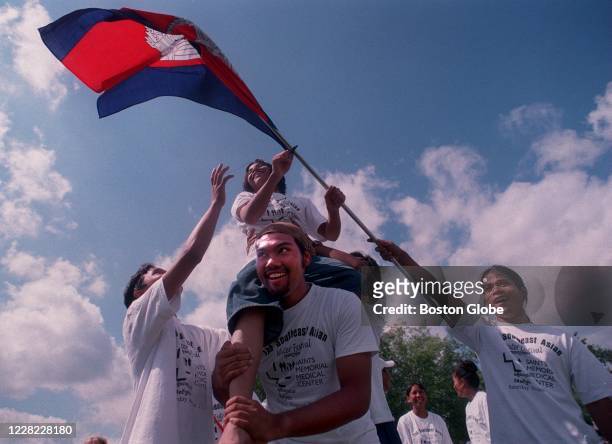 Samoeun Sok holds up Sarterday Ven, carrying the Cambodian flag, during the Southeast Asian community festival in Lowell, MA on AUg. 23, 1997.