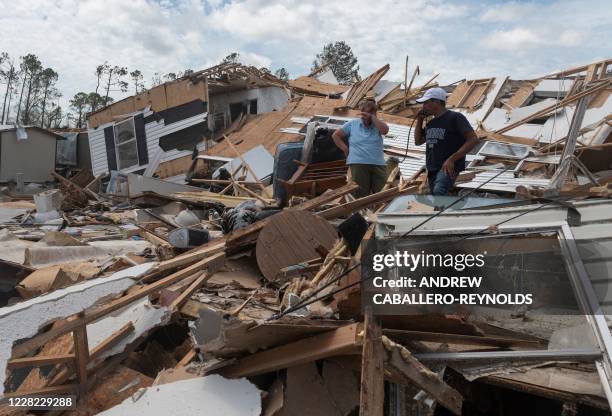 Couple react as they go through their destroyed mobile home following the passing of hurricane Laura in Lake Charles, Louisiana, on August 27, 2020....