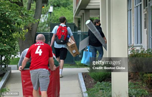 Astudent walks up a path to his dorm, helped by his parents in Medford, MA on Aug. 27, 2020. Tufts University moves in during the COVID-19 pandemic....