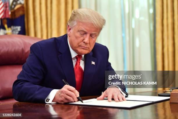 President Donald Trump signs the pardon for Alice Johnson, in the Oval Office of the White House in Washington, DC, on August 28, 2020. - Trump...