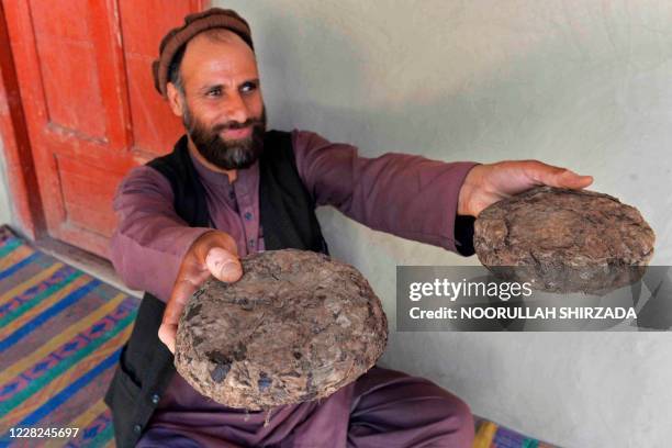 This photo taken on June 28, 2020 shows 37-year-old farmer Mohaiyudeen displaying packages of opium after harvesting it from his poppy fields in the...