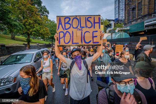 Participant holding a Abolish Police sign at the protest. A coalition of activists and organizations led by activist, poet, and organizer Selu...
