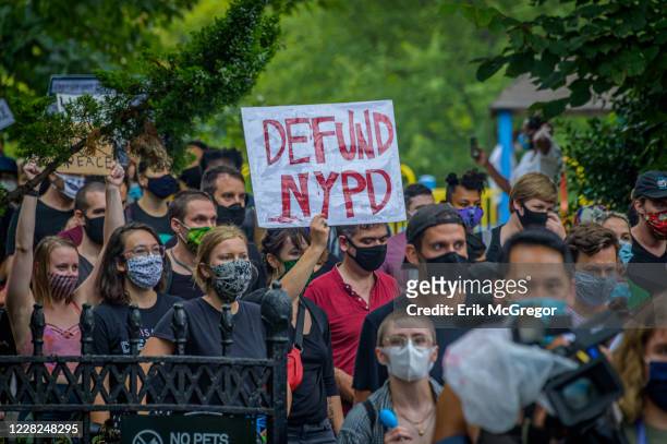 Participant holding a Defund NYPD sign at the protest. A coalition of activists and organizations led by activist, poet, and organizer Selu gathered...