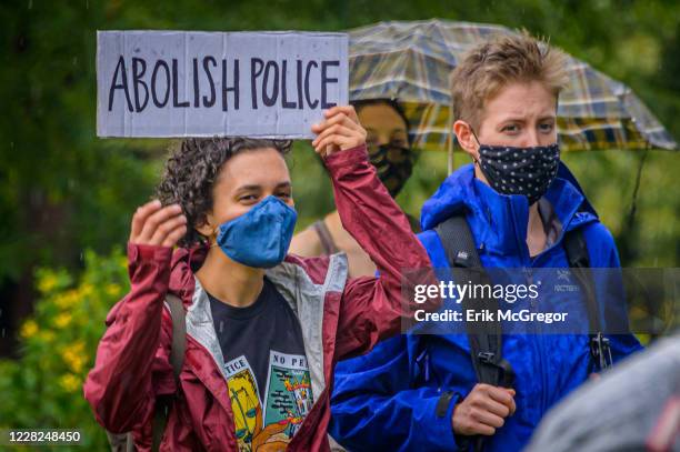 Participant holding a Abolish Police sign at the protest. A coalition of activists and organizations led by activist, poet, and organizer Selu...