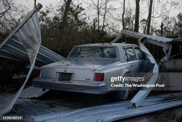 Pieces of metal surround a car near a home that was damaged after Hurricane Laura made landfall along the Texas-Louisiana border in Lake Charles,...